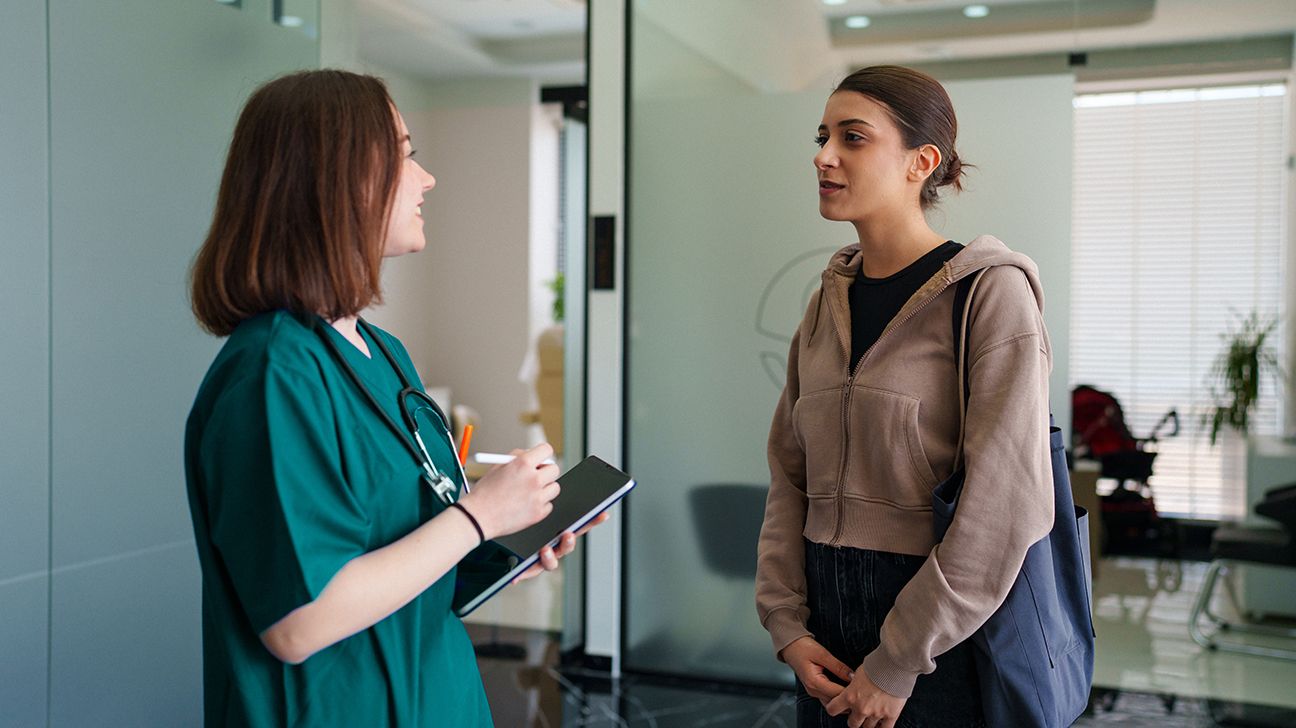 Young female patient talks with healthcare worker